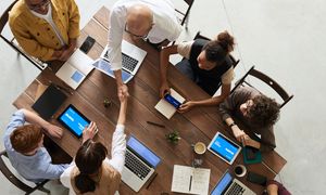 Von oben: Personen an einem Tisch arbeiten zusammen